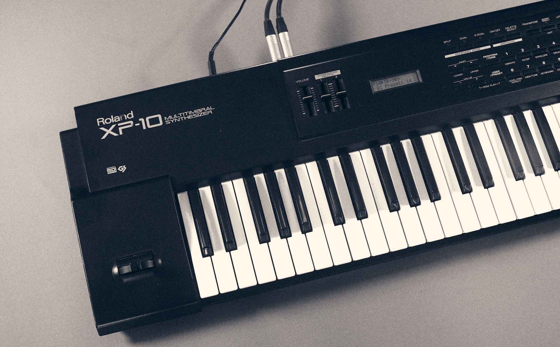 A black and white image of a Roland XP-10 synthesizer